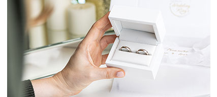 two gold wedding bands in a ring box